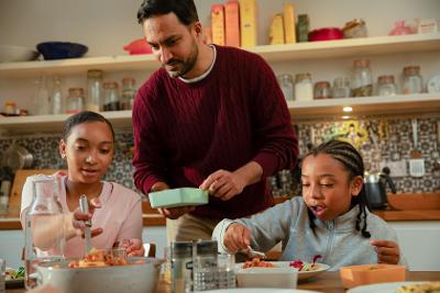 Dad serving food to two children 